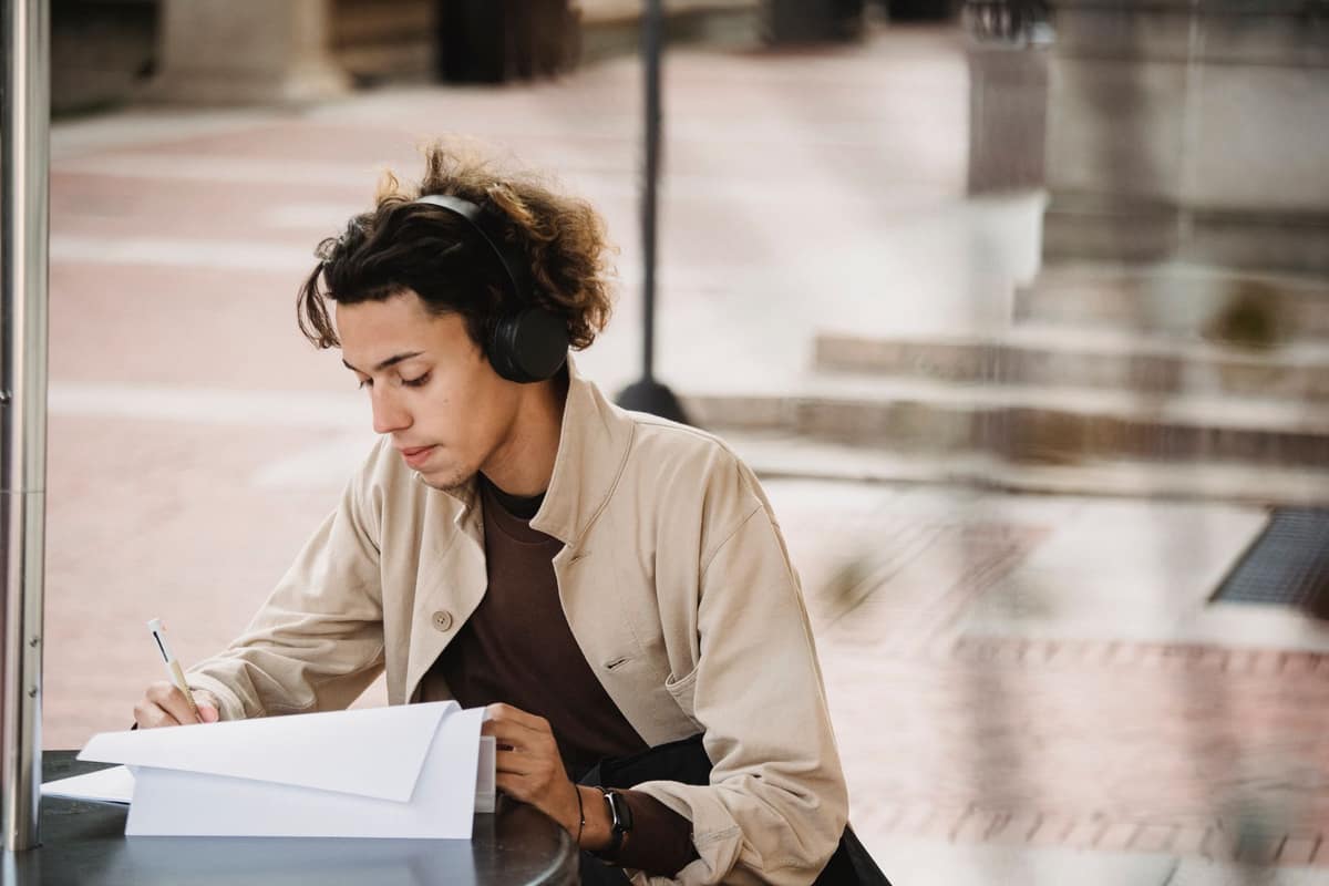 A student wearing headphones at a bright desk