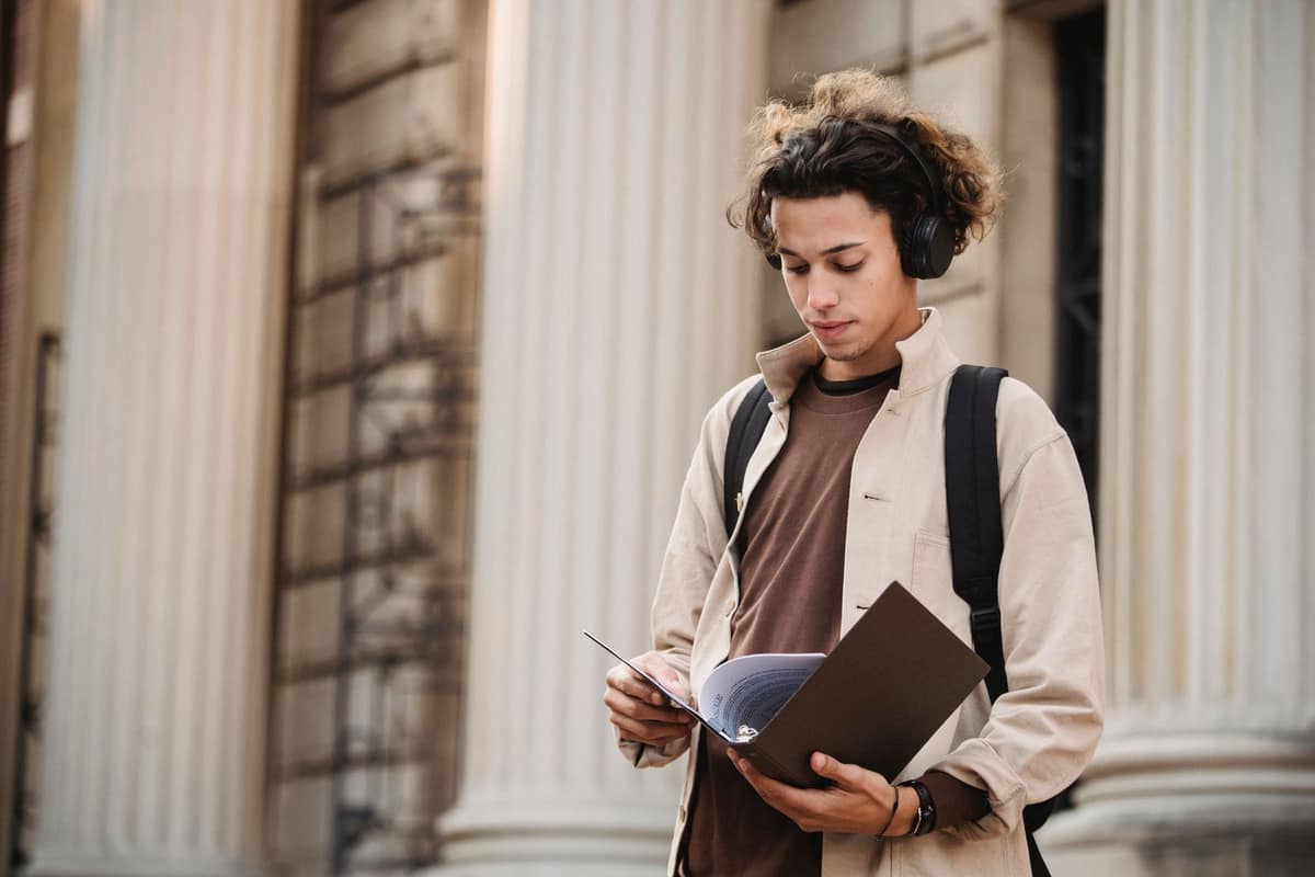 A student wearing headphones outside a university building