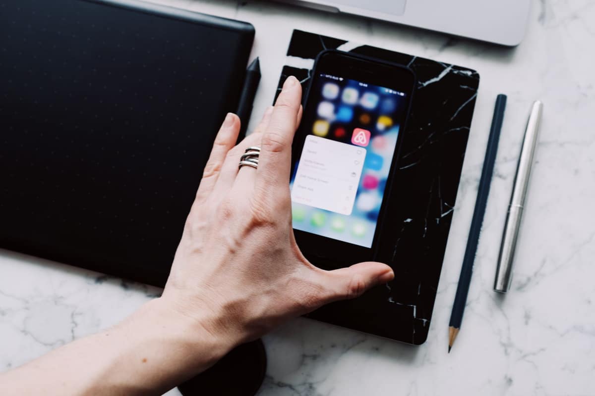 A phone showing app subscriptions on a bright desk