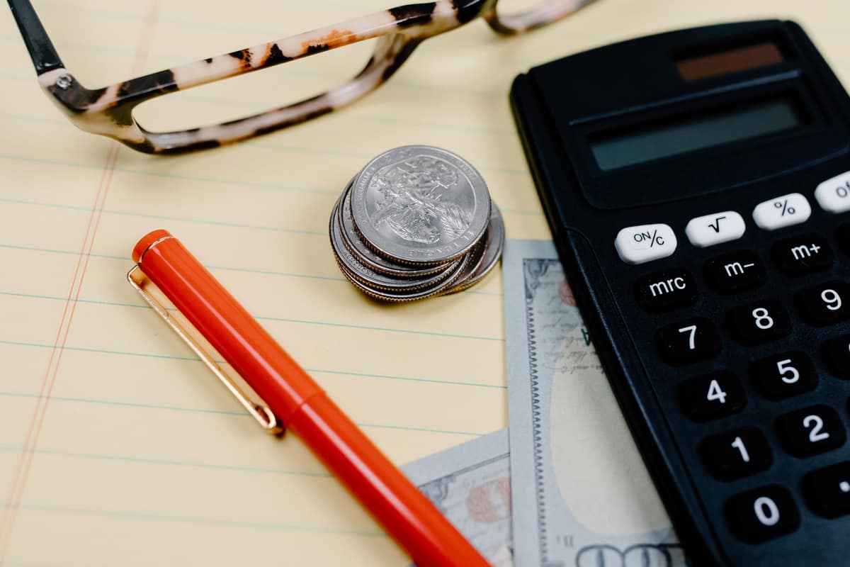Coins and a phone on a bright desk