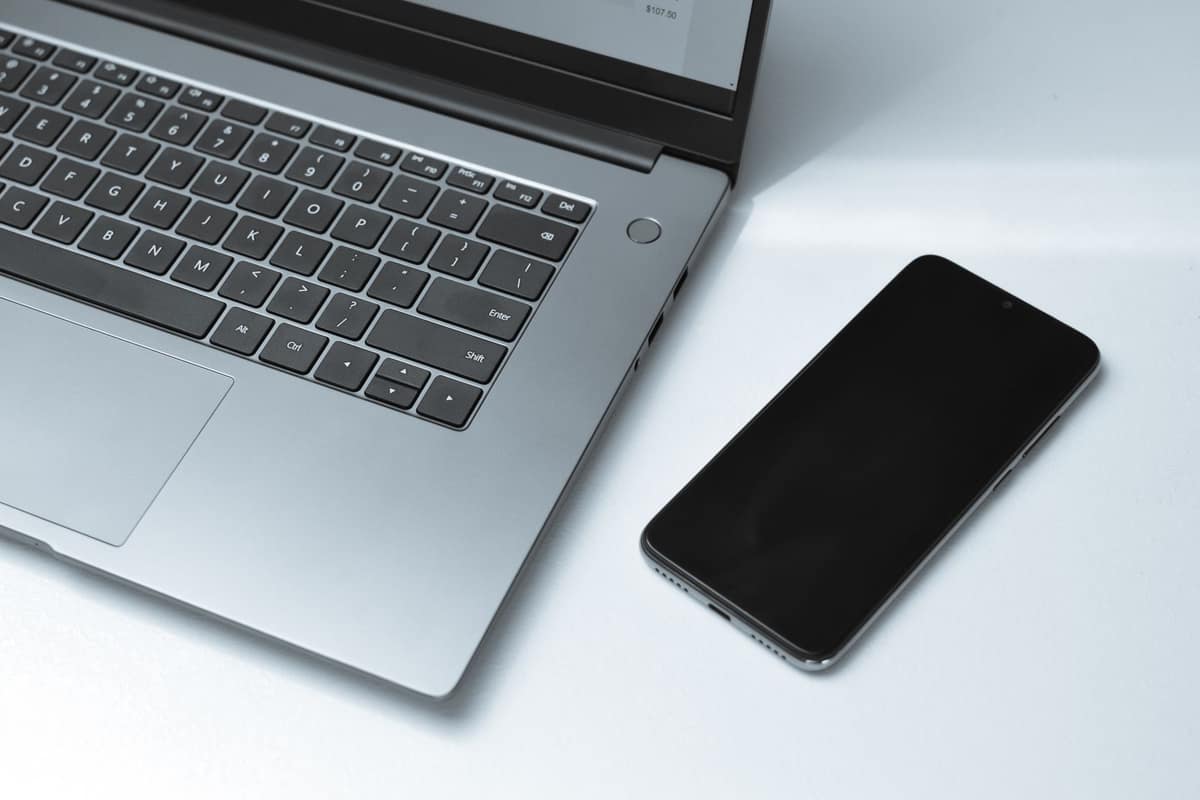 A phone and a laptop showing online offers on a bright desk