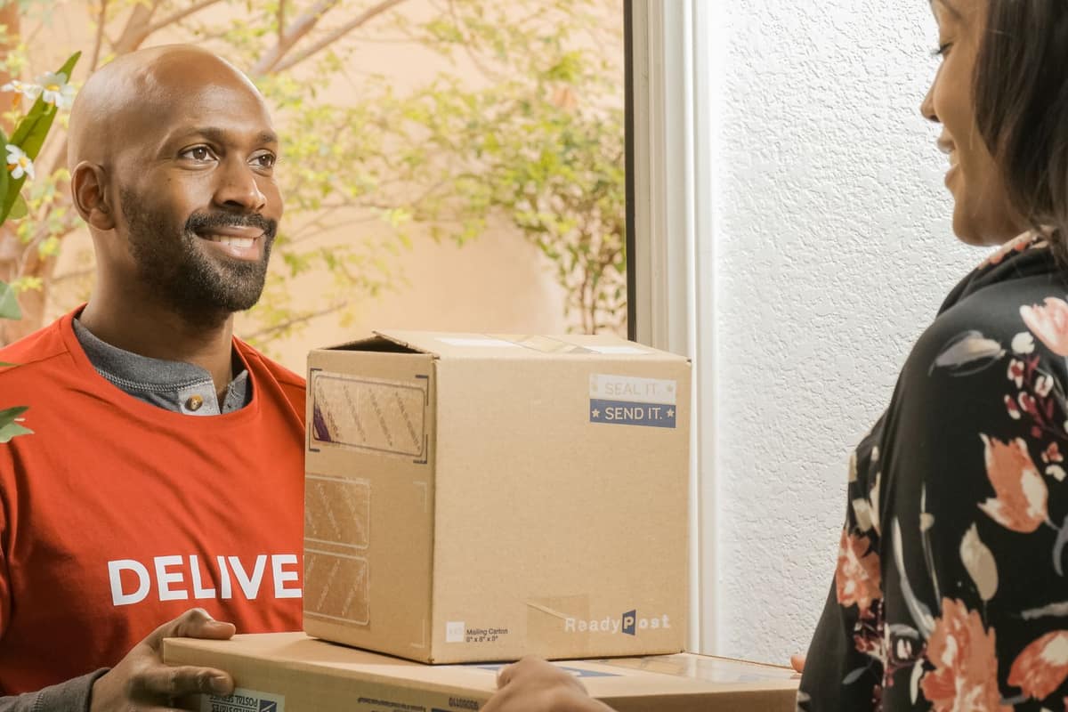 A delivery driver handing packages to someone at their door