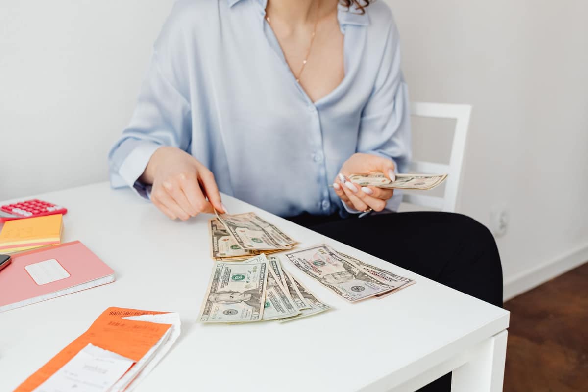 A student counting money at a bright desk