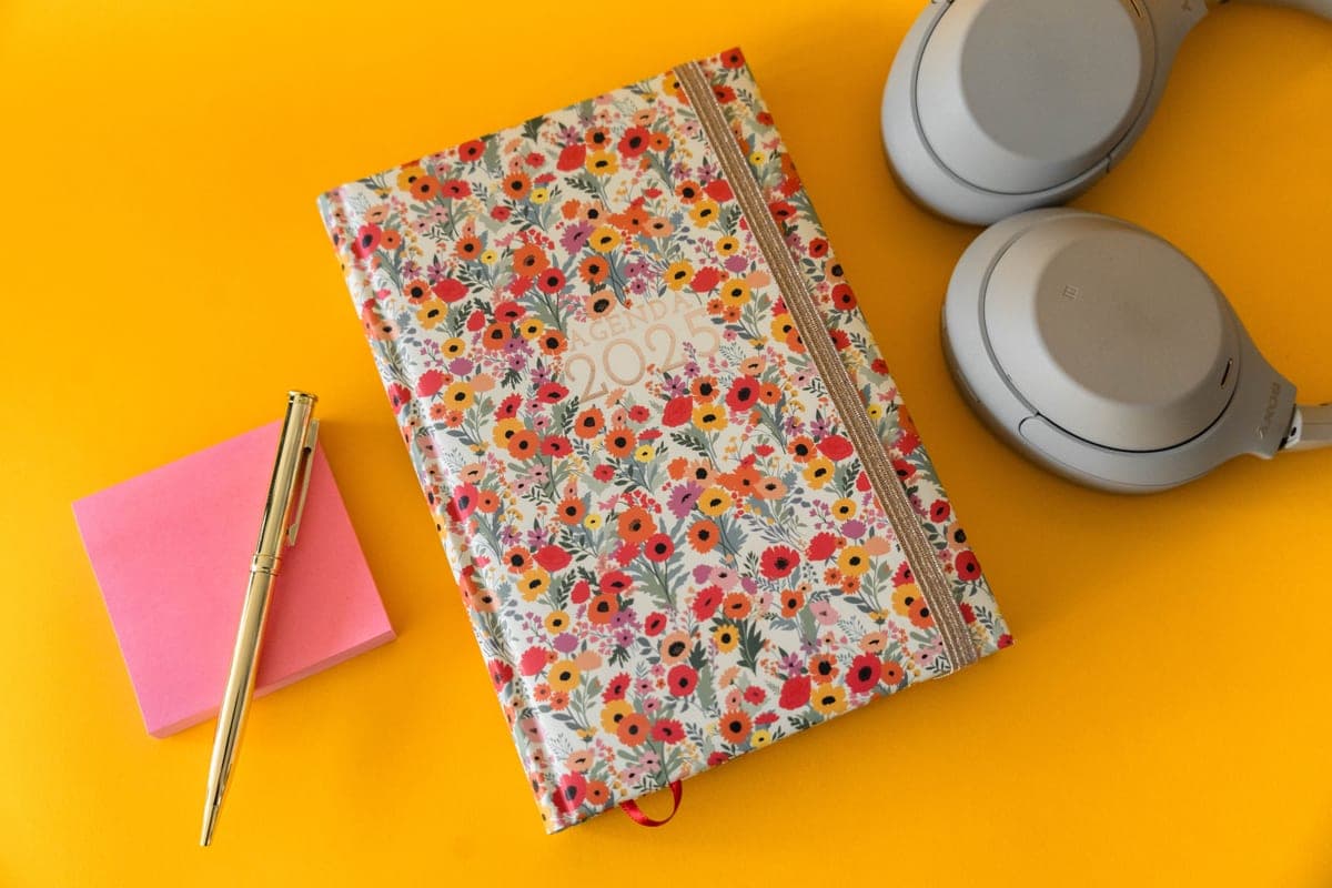 A paper calendar and planner open on a bright desk