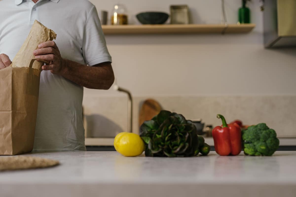 Grocery bags with fresh produce in a bright kitchen