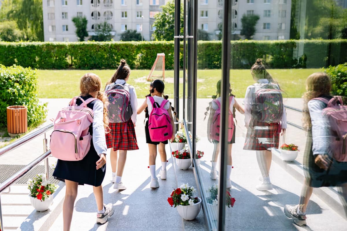 High school students with backpacks outside on a sunny day