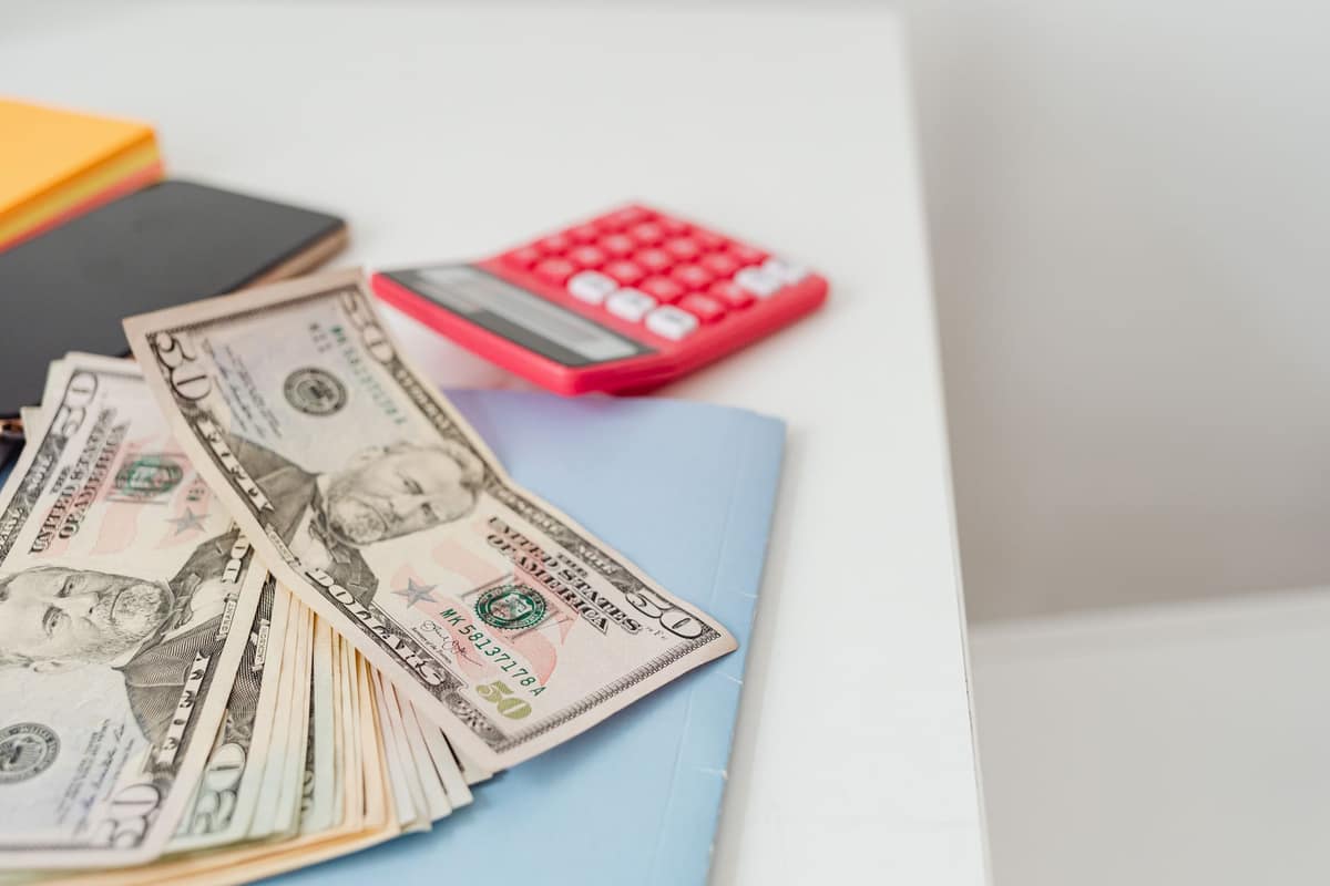 A calculator and notebook on a bright desk