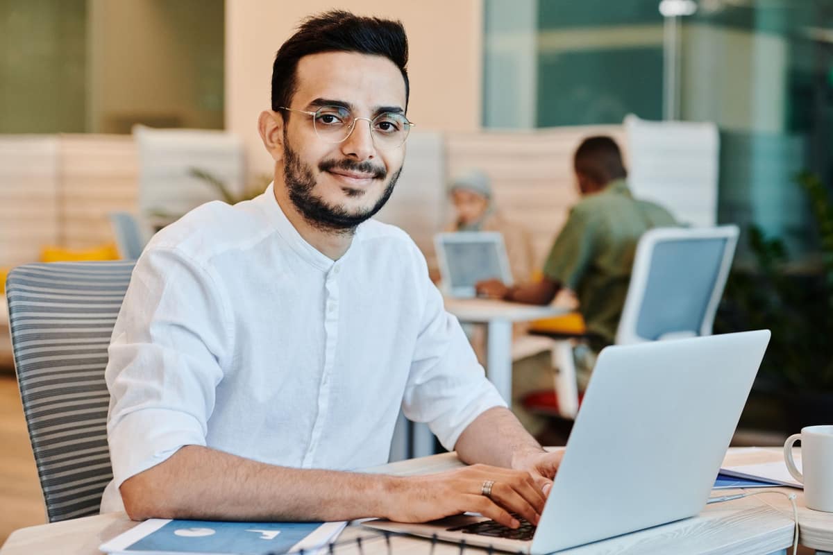 A young professional working on a laptop in a bright office