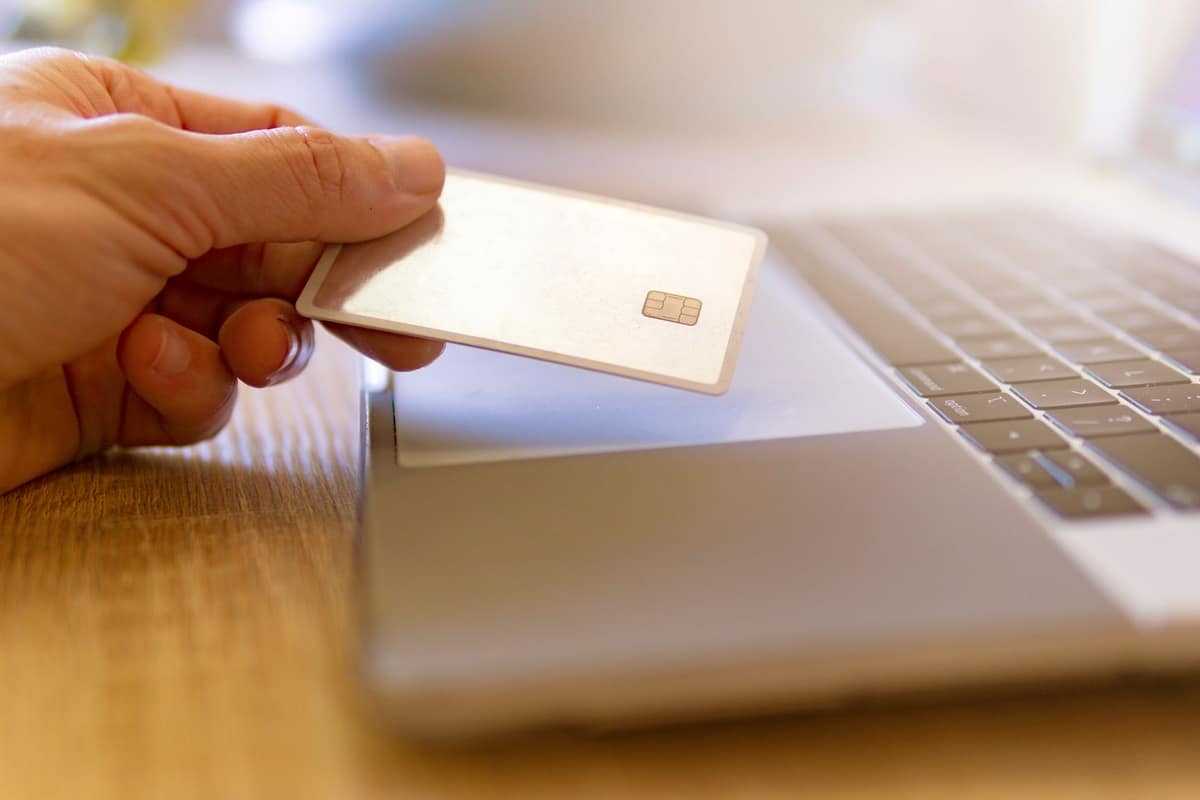 A payment card beside a laptop on a bright desk
