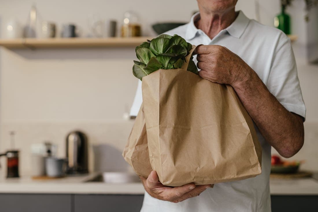 A bag of fresh groceries on a bright kitchen counter