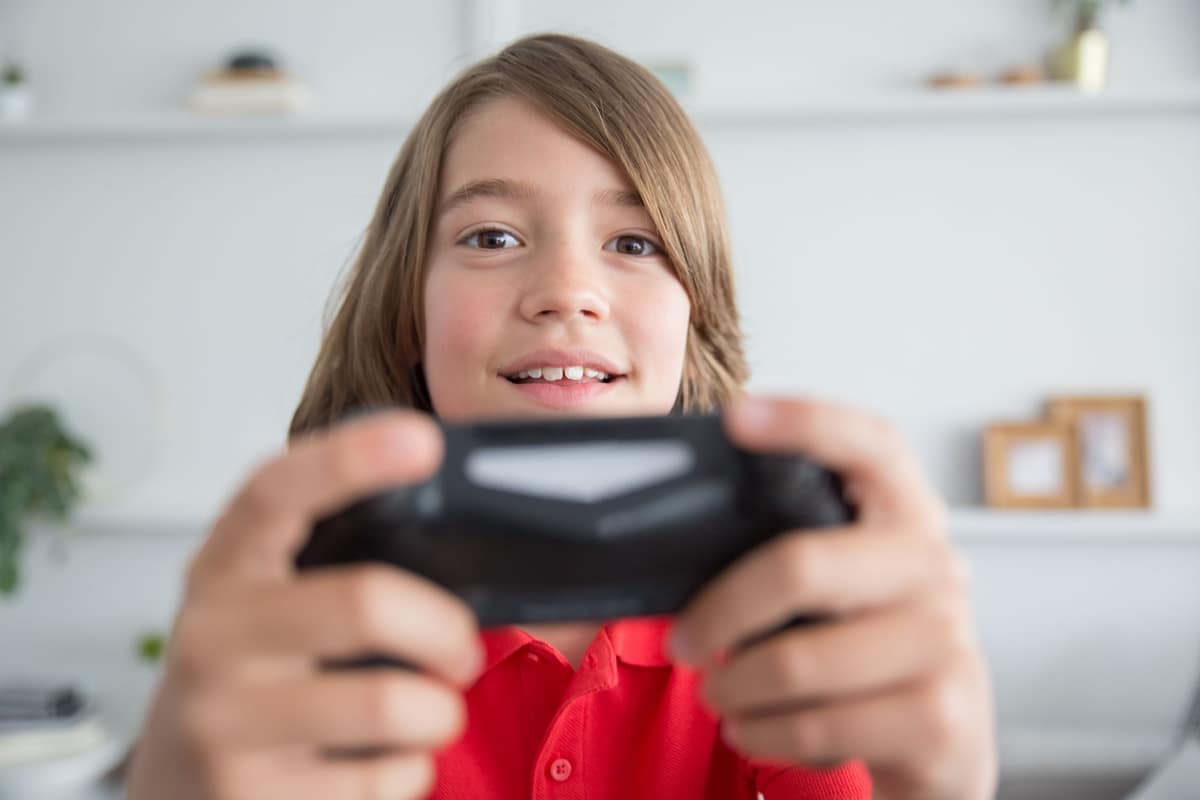 A young person holding a game controller in a bright room