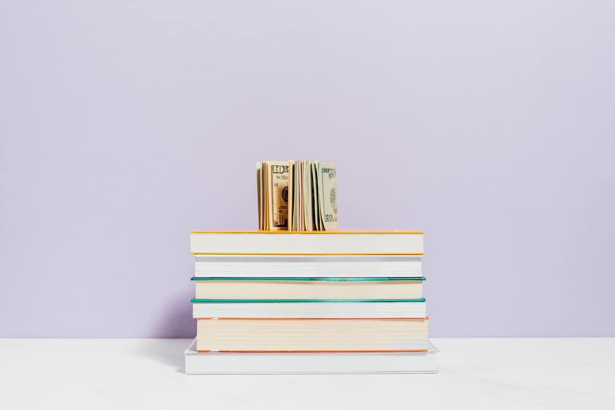 Used textbooks stacked on a bright desk
