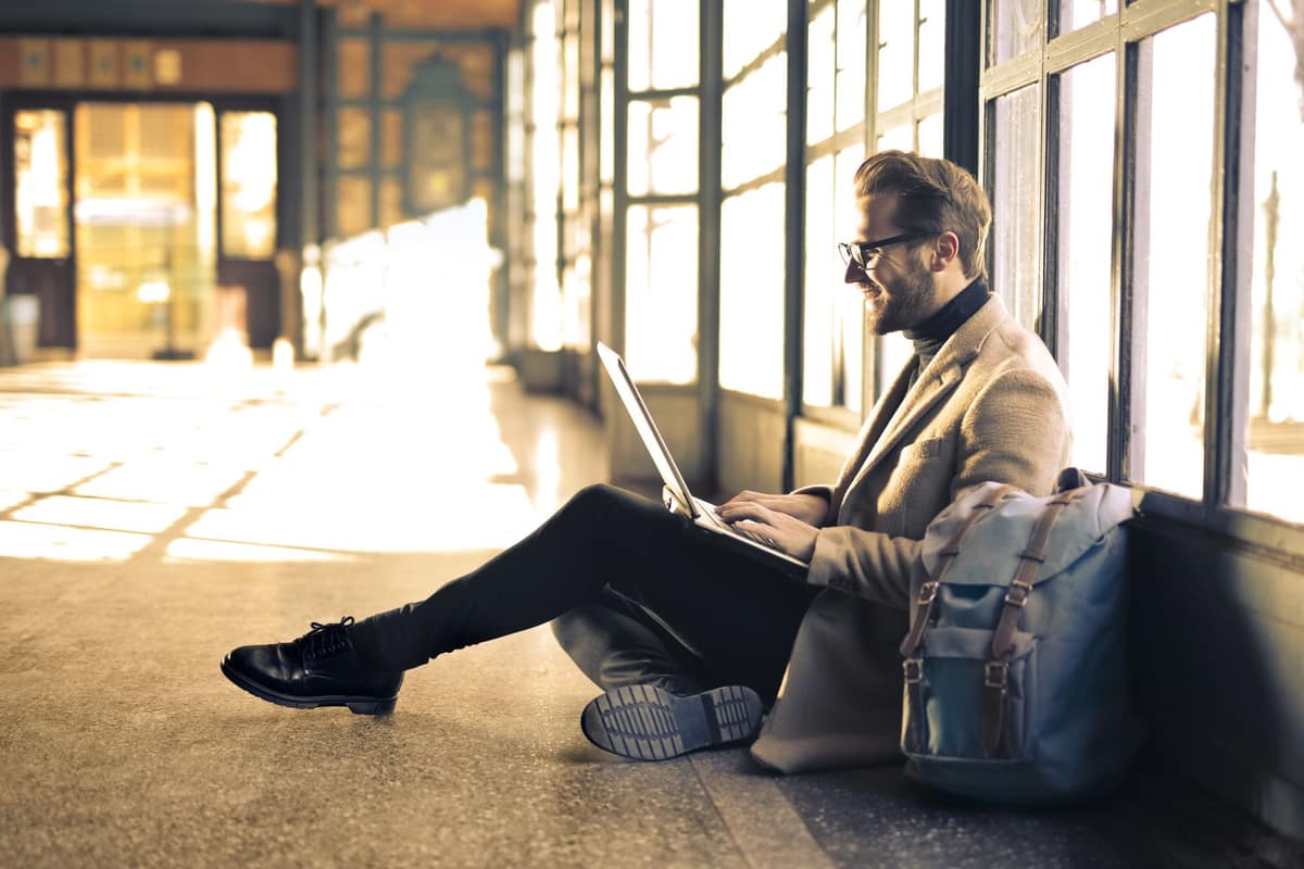 Someone waiting at a laptop by a bright window