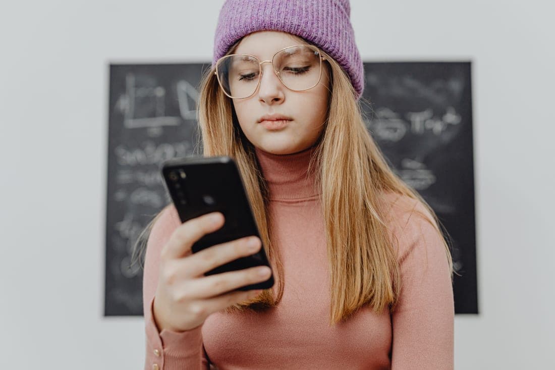 A student checking their phone screen in daylight