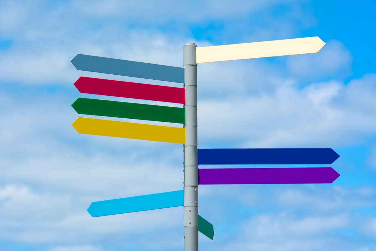 A signpost pointing in two directions against a blue sky